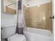 Bright bathroom featuring a white toilet and bathtub and a shower with tan tiles at 7801 W 35Th Ave # 406, Wheat Ridge, CO 80033