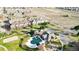 Aerial view of a community featuring townhomes, green spaces, a community center with pool, a playground, and common areas at 9756 Ash Ln, Thornton, CO 80229