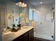 Modern bathroom with double vanity, quartz counters, glass enclosed shower, and stylish fixtures at 9756 Ash Ln, Thornton, CO 80229