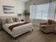 Inviting bedroom with a queen bed, neutral tones, ample natural light, and a cozy seating area at 9756 Ash Ln, Thornton, CO 80229