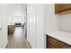 Hallway leading to a modern kitchen with stainless steel appliances and hardwood floors at 9756 Ash Ln, Thornton, CO 80229