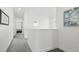 Well-lit upstairs hallway with neutral carpet, white walls, and decorative wall art at 9756 Ash Ln, Thornton, CO 80229