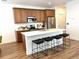 Well-lit kitchen with modern island, dark bar stools, and stainless steel appliances at 9756 Ash Ln, Thornton, CO 80229