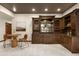 This stylish bar features dark wood cabinets, granite counters, and a seating area at 7115 Parkwood Ln, Castle Pines, CO 80108