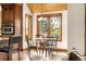 Cozy breakfast nook with wood-trimmed windows, vaulted ceiling and a charming chandelier at 7115 Parkwood Ln, Castle Pines, CO 80108