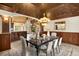 Spacious dining room boasts wainscoting, and a view into the living room with fireplace at 7115 Parkwood Ln, Castle Pines, CO 80108