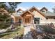 Inviting home featuring a beautiful wood porch, stone accents, and mature landscaping, creating great curb appeal at 7115 Parkwood Ln, Castle Pines, CO 80108