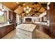 Bright kitchen featuring a center island, granite countertops, wood cabinetry, and tile floors at 7115 Parkwood Ln, Castle Pines, CO 80108