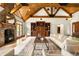 Open-concept living room boasts a stone fireplace, wood beams, and seamless integration with the outdoors at 7115 Parkwood Ln, Castle Pines, CO 80108