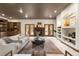 Cozy living room featuring a stone fireplace, custom built-ins, hardwood doors, and recessed lighting at 7115 Parkwood Ln, Castle Pines, CO 80108