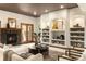 Bright living room boasts built-in shelving, a fireplace, and hardwood doors leading to the outside at 7115 Parkwood Ln, Castle Pines, CO 80108