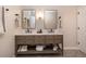 Modern bathroom boasts double sinks, a wood vanity with storage, black hardware, and stylish patterned tile floors at 2879 Hilltop Ct, Broomfield, CO 80023