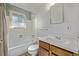 Bathroom featuring a white tub and vanity with a wooden cabinet at 2813 S Ivan Way, Denver, CO 80227