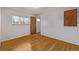 An empty bedroom featuring hardwood floors and a window overlooking a tree at 2813 S Ivan Way, Denver, CO 80227