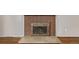 Close-up of the red brick fireplace with metal doors and hearth in a room with hardwood floors at 2813 S Ivan Way, Denver, CO 80227