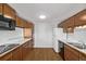 Functional kitchen featuring wooden cabinets, a white refrigerator, black dishwasher, and hardwood floors at 2813 S Ivan Way, Denver, CO 80227