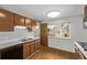 Functional kitchen featuring wooden cabinets, a white refrigerator, black dishwasher, and hardwood floors at 2813 S Ivan Way, Denver, CO 80227