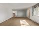 View of a spacious living room with carpet, a window with curtains, and an open doorway at 2813 S Ivan Way, Denver, CO 80227
