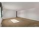 An empty, spacious living room featuring neutral carpet, baseboard heaters, and a window at 2813 S Ivan Way, Denver, CO 80227