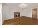 View of the living room featuring a fireplace, hardwood floors, a chandelier, and a wooden door at 2813 S Ivan Way, Denver, CO 80227