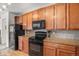 Functional kitchen featuring stainless steel appliances, granite countertops, and wood cabinetry at 5534 Lewis St # 202, Arvada, CO 80002