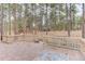 Back patio featuring brick pavers and wood railings overlooking the pine tree filled lot, with a distant view of the house at 70 Long Bow Cir, Monument, CO 80132