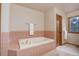 Bathroom showcasing a large soaking tub and tiled walls, with a view from the window at 70 Long Bow Cir, Monument, CO 80132