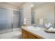 Bathroom with a shower over bath with glass doors, a classic vanity and mirror at 70 Long Bow Cir, Monument, CO 80132