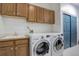 Functional laundry room with a utility sink, ample cabinet space, and modern washer and dryer at 70 Long Bow Cir, Monument, CO 80132
