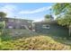 A view of the home's backyard and exterior with a grass lawn at 220 S Raleigh St, Denver, CO 80219