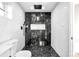 Modern bathroom featuring black and white tile, a glass shower, and updated fixtures at 220 S Raleigh St, Denver, CO 80219