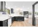 Open kitchen with modern black cabinets, white countertops, updated stainless appliances, and hardwood floors at 220 S Raleigh St, Denver, CO 80219