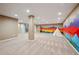 Finished basement with neutral carpet, large support beam, and doorway with stair access at 6595 Meade Ct, Arvada, CO 80003