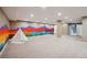 Finished basement featuring colorful mountain-themed mural, neutral carpet, and recessed lighting at 6595 Meade Ct, Arvada, CO 80003