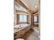 Bathroom featuring a soaking tub with a stone surround and a glass shower at 6595 Meade Ct, Arvada, CO 80003