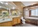 Bathroom boasts double sinks, granite counters, tile floors and soaking tub at 6595 Meade Ct, Arvada, CO 80003