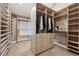 Spacious walk-in closet featuring custom shelving, drawers and ample storage space at 6595 Meade Ct, Arvada, CO 80003