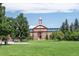 Historic brick building on a large green lawn with mature trees under a sunny sky at 6595 Meade Ct, Arvada, CO 80003