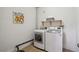 Laundry room features washer and dryer, storage shelf and laminate floors at 6595 Meade Ct, Arvada, CO 80003