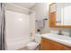 Bathroom featuring a shower-tub combo with white tile surround, vanity, and updated fixtures at 857 S Van Gordon Ct # G208, Lakewood, CO 80228