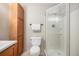 Bright bathroom features a glass-enclosed shower, white toilet, and wooden storage at 857 S Van Gordon Ct # G208, Lakewood, CO 80228