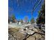 Outdoor pool and lounge area features stone seating and mature trees under a bright blue sky at 857 S Van Gordon Ct # G208, Lakewood, CO 80228