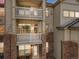 Multi-story condo building featuring private balconies with white railings and brick and siding accents at 5726 N Genoa Way # 204, Aurora, CO 80019