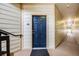 Hallway of unit with dark blue door and beige walls at 5726 N Genoa Way # 204, Aurora, CO 80019