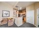 Cozy living room featuring armchairs leading into kitchen with stainless steel appliances and wooden cabinetry at 5726 N Genoa Way # 204, Aurora, CO 80019