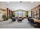 Expansive community living room with vaulted ceilings, stone fireplace, bookshelves, and comfortable seating at 5726 N Genoa Way # 204, Aurora, CO 80019