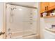 Shower and bath combination with sliding glass door and integrated shelving at 2325 S Linden Ct # 101, Denver, CO 80222