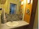 Bathroom featuring a vanity, decorative mirror, and tile backsplash at 2325 S Linden Ct # 101, Denver, CO 80222