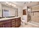 Bathroom featuring double sinks, dark wood cabinets, tile flooring, and a glass-enclosed shower at 3310 S Oneida Way, Denver, CO 80224