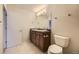 Bathroom with double sinks, dark wood cabinets, tile flooring, and great lighting at 3310 S Oneida Way, Denver, CO 80224